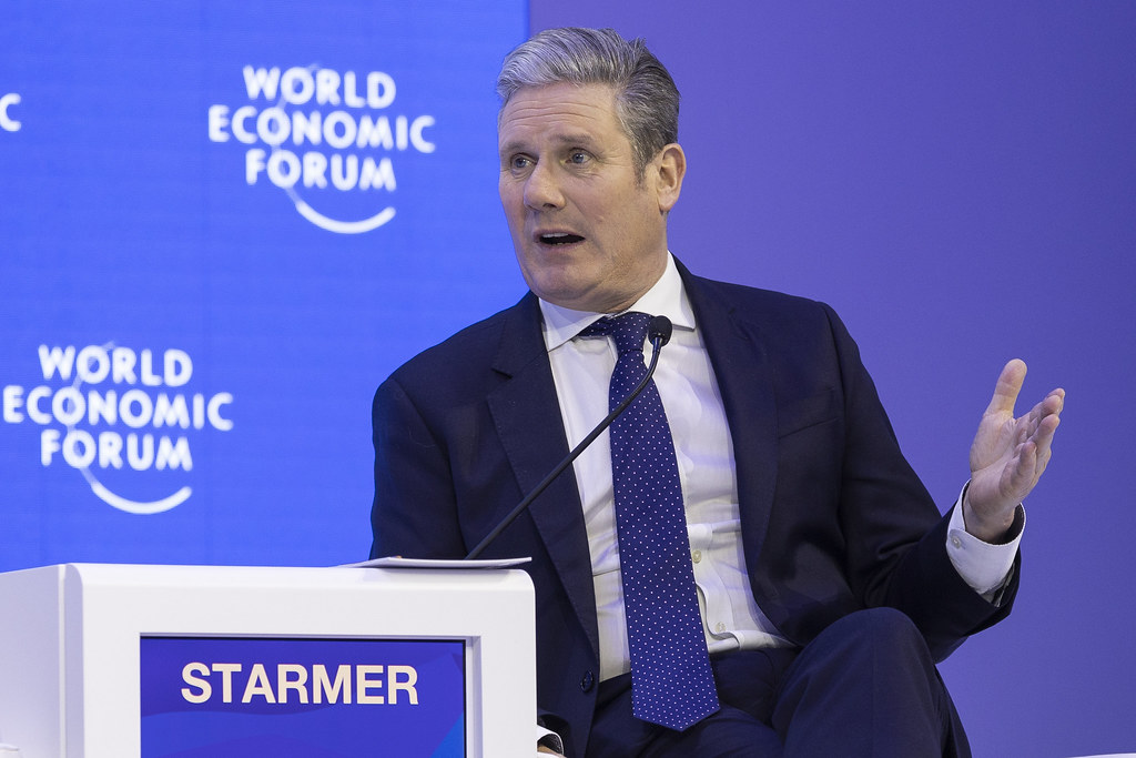 Keir Starmer standing next to a podium with the word "STARMER" written on the front